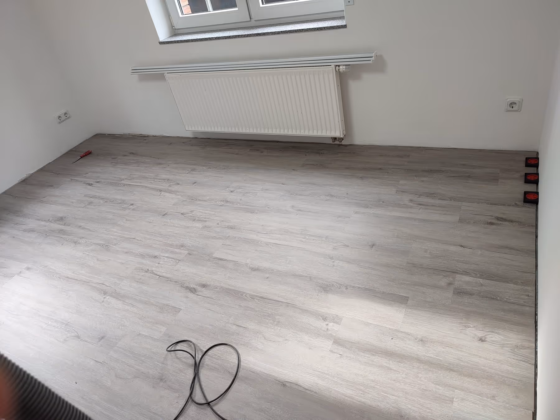 Neu verlegter Bodenbelag mit Sockelleisten